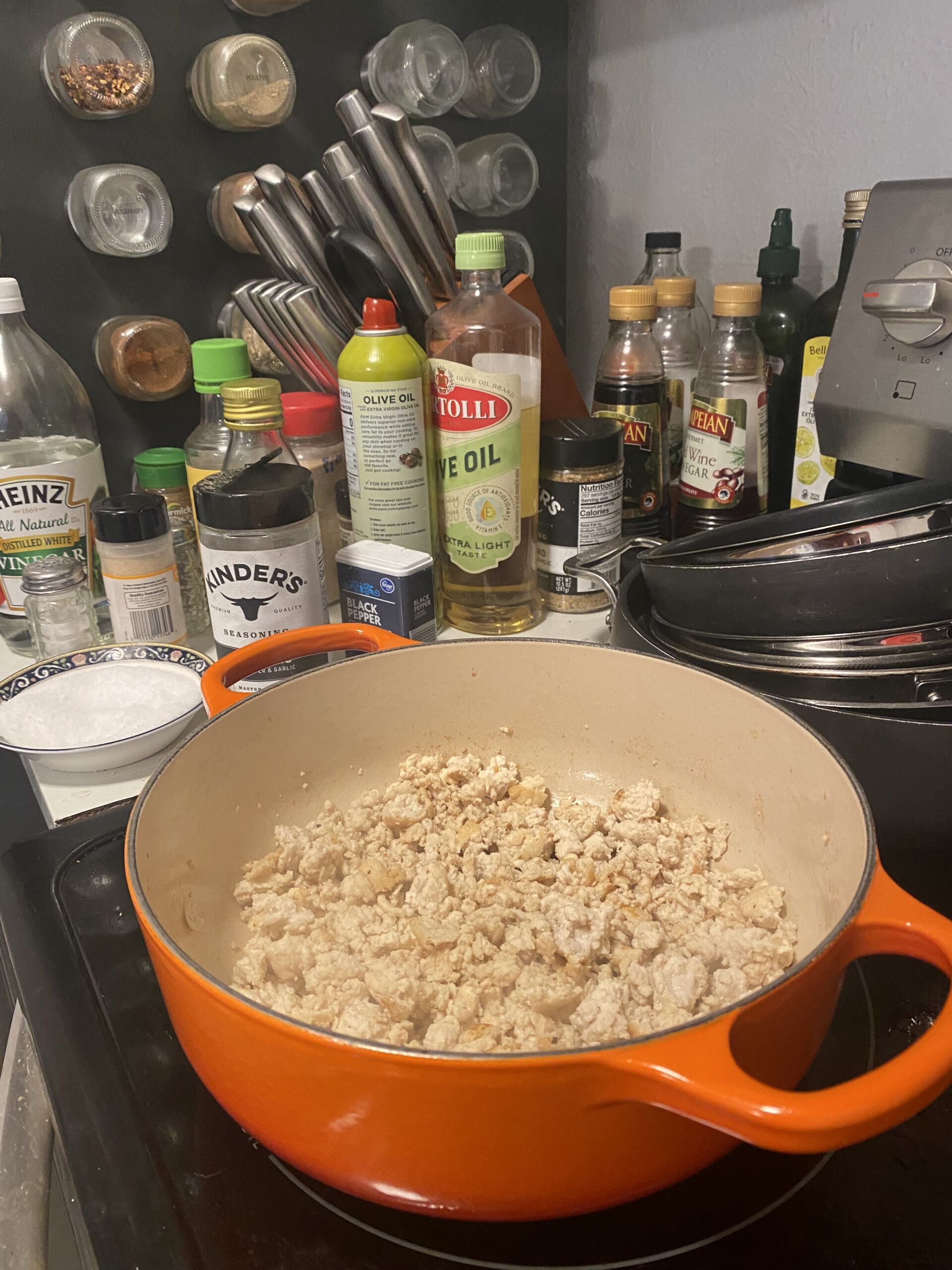 Ground chicken browning in an orange Dutch oven for lettuce wraps