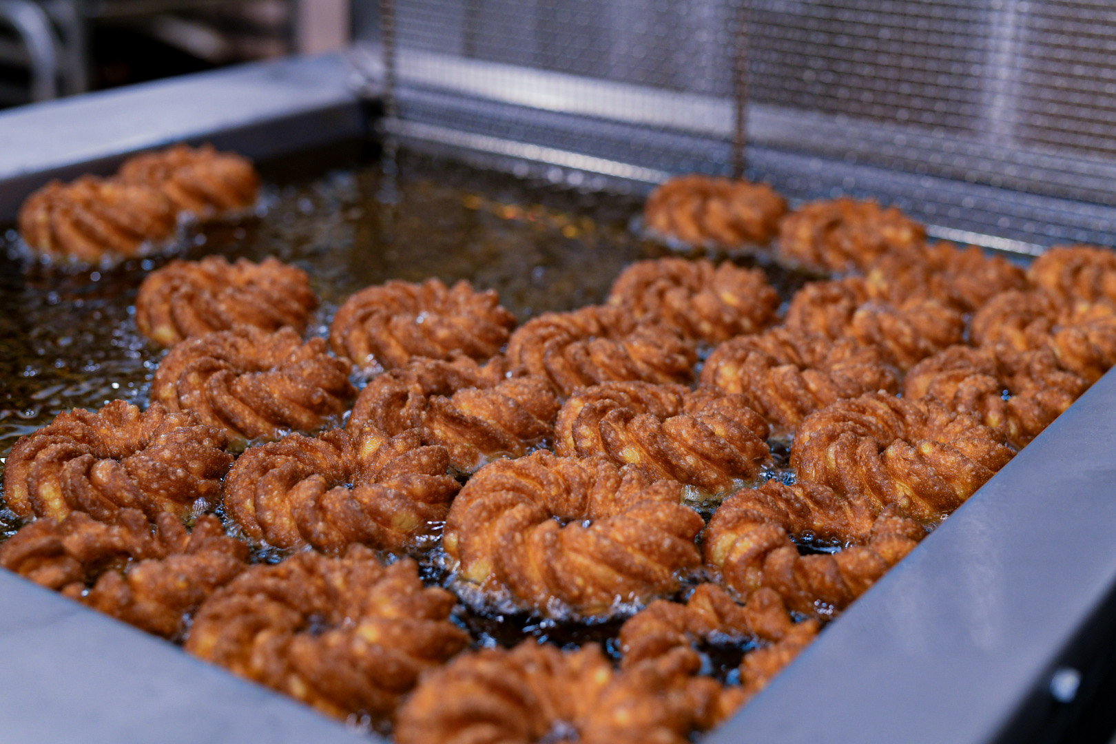 Crullers frying fresh at La Rue Doughnuts in Trinity Groves