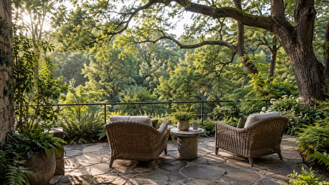 Stone terrace with woven chairs overlooking a leafy woodland canopy