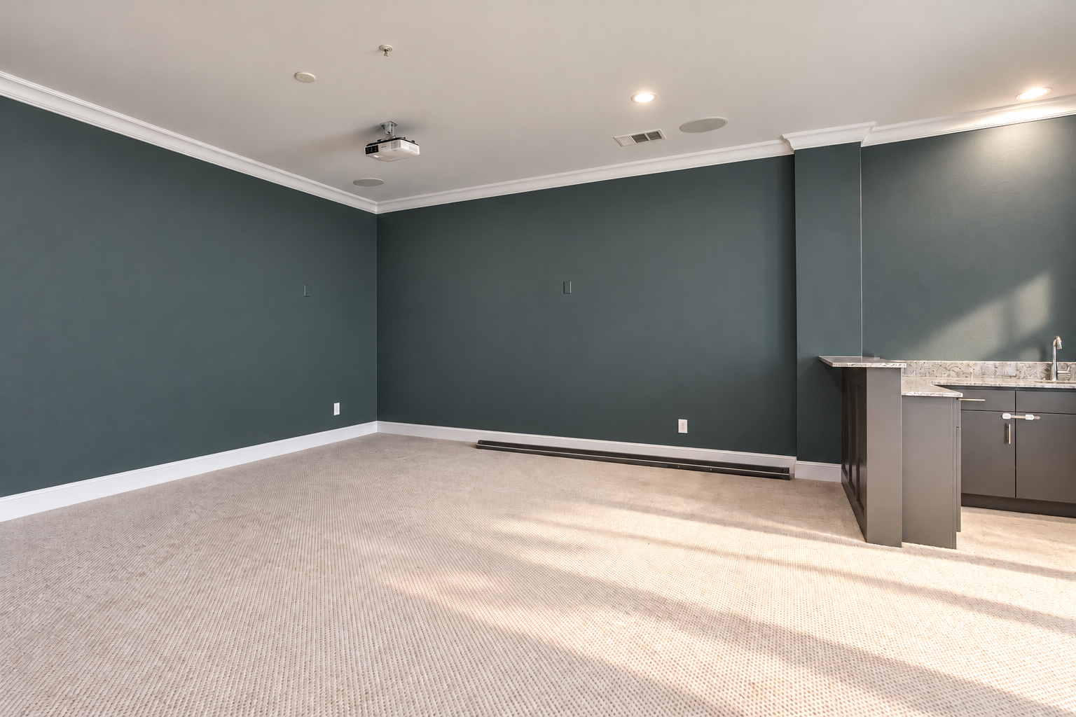 Media room with green-charcoal walls and wet bar at 2211 Worthington Street