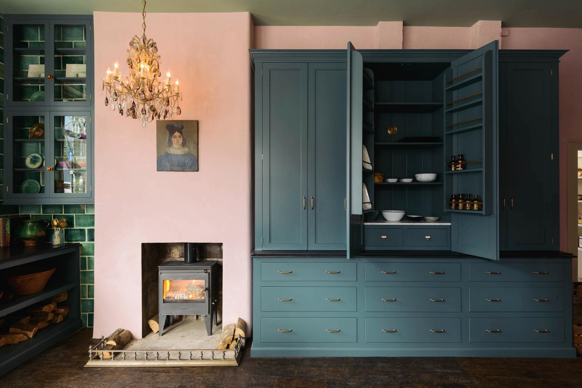 Clerkenwell blue pantry cupboards beside a pink chimney and green tiles.